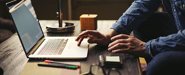 Male hands with laptop. Man typing on computer