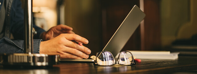 Male hands with laptop. Man typing on computer