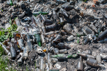 Garbage dump of burnt glass bottles, top view, closeup