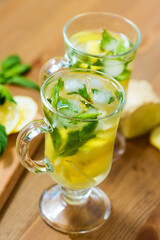 Two glasses with a homemade drink of lemon, mint and ginger