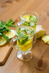 Two glasses with a homemade drink of lemon, mint and ginger