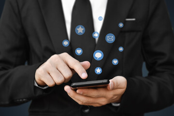 Close-up of businessman hands using mobile smartphone with social media icon. Idea for business, online marketing and technology.
