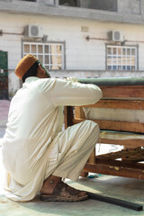 Carpenter man in cap working on a wooden sofa