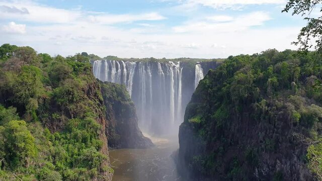 Panorama view at Victoria Falls, Zambia, the largest Waterfall with a blue Sky,  and steam in the Air