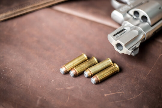 .44 magnum concel gun with bullet on leather background