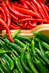 a pile of vegetables red and green hot chili peppers as background