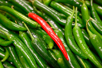 vegetables one red and pile green hot chili peppers as background