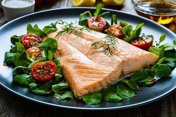 Steamed salmon fillet with vegetables on wooden table