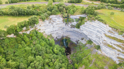 aerial view of a natural waterfall falling from a hill