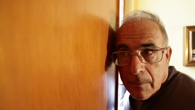 Anziano Signore sente chi sta bussando alla porta di casa sua e comicamente si allontana e non apre