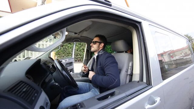 Ragazzo in giacca e occhiali da sole si diverte a ballare nel suo furgone prima di partire