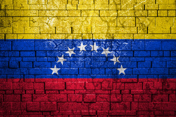 National flag of Venezuela on brick  wall background.The concept of national pride and symbol of the country. Flag  banner on  stone texture background.