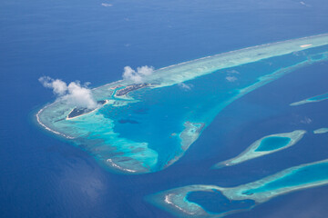 Fototapeta na wymiar Aerial view of Maldives atolls is the world top beauty. Maldives tourism. Luxury travel destination, amazing nature environment, islands atoll and coral reef. Tropical landscape, aerial view
