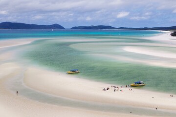 Speed boats leaving tourists on the white sand beach of Whitsunday island, Australia 