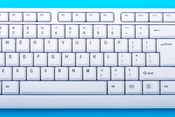 Keyboard isolated. White keyboard on blue background. Top view. Close up
