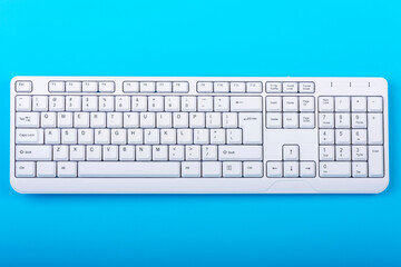 Keyboard isolated. White keyboard on blue background. Top view. Close up