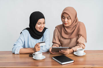 two muslim woman shop online using credit card for payment