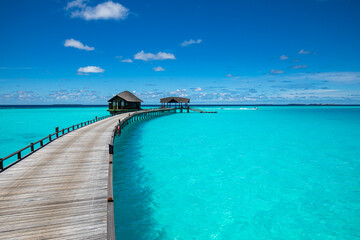 Tropical landscape of Maldives beach. Seascape panorama, luxury water villa resort with wooden pier or jetty. Luxury travel destination background for summer holiday and vacation concept.