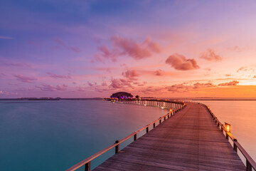 Amazing sunset sunrise sky and reflection on calm sea, Maldives beach landscape of luxury over water villas bungalows. Exotic scenery of summer vacation and holiday background. Tropical seascape sky