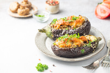 Baked aubergine or eggplant boats stuffed with mushrooms, vegetables and cheese