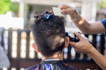 Asian businessman making haircut at home garden. Social distancing and New normal lifestyle.