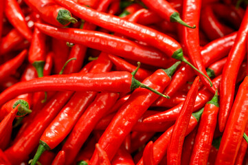 a pile of vegetables red hot chili peppers as background