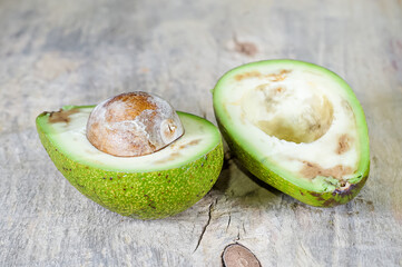 Cut ugly avocado with black spots closeup