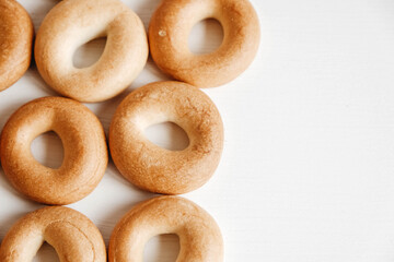 Drying or mini round bagels on a white wooden background. Top view. Copy, empty space for text