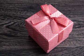 pink gift box with a bow on a gray wooden background