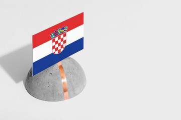 Croatia flag tagged on rounded stone. White isolated background. Side view minimal national concept.