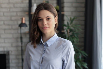 Cheerful woman student professional standing at home in office looking at camera.