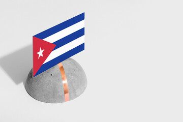 Cuba flag tagged on rounded stone. White isolated background. Side view minimal national concept.