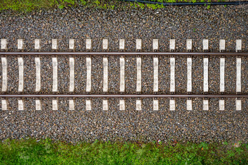 some Railway tracks on a railway track bed lead through the picture