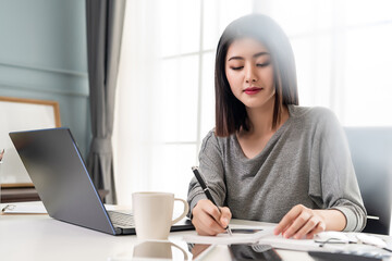 Working Woman writing a note on her office table