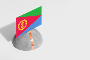 Naklejka premium Eritrea flag tagged on rounded stone. White isolated background. Side view minimal national concept.