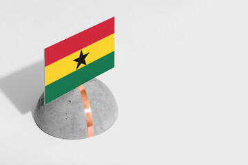 Ghana flag tagged on rounded stone. White isolated background. Side view minimal national concept.