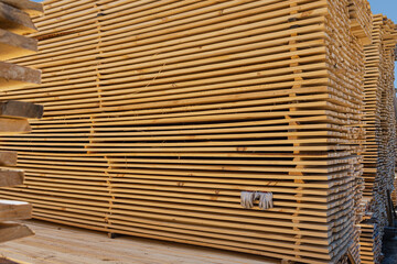 Warehouse for sawing boards on a sawmill outdoors. Timber mill, storage of planed wooden boards.