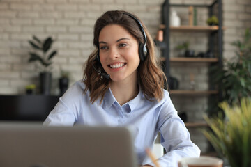 Freelance operator talking with headsets and consulting clients from home office.