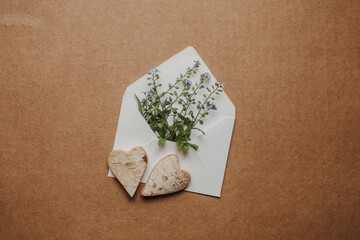 Blumige Herzensbotschaft - Briefumschlag mit zarten Blume und zwei Herzen aus Holz