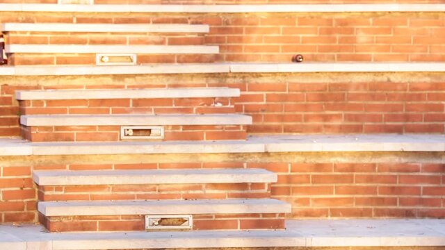 Ragazza mora con cappello si scatena in un ballo sopra delle gradinate di mattoncini rossi