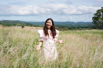 Fototapeta na wymiar happy girl standing and smile in flower grass field