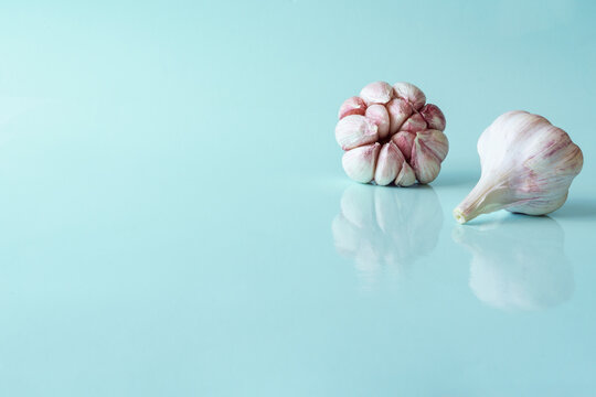 three heads of garlic on blue background