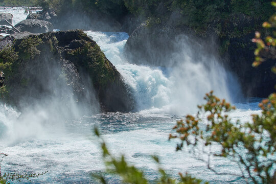 PETROHUE, CHILE - FEBRUARY 11, 2020: The waterfalls, rapids and tourists of Petrohue on a sunny day in the lake region of Chile, near of Puerto Varas. Turquoise water. © Alex