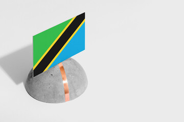 Tanzania flag tagged on rounded stone. White isolated background. Side view minimal national concept.