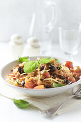 Spaghetti Pasta with Vegetables and fresh Basil on bright wooden Background.