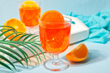 Glasses with fresh homemade orange sweet iced tea or cocktail, lemonade with thyme. Refreshing cold drink. Summer party.