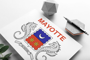 Mayotte flag on minimalist paper background. National invitation letter with stylish pen on stone. Communication concept.