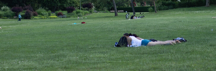 Menschen sitzen im Gras im Park und ein Picknick machen und sich sonnen