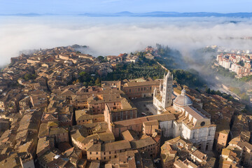 Fototapeta na wymiar aerial view of the city of Siena with the fog Tuscany