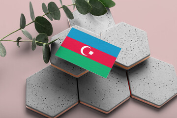Azerbaijan flag on hexagon stylish stones. Pink copy space background. Flat lay, top view minimal national concept.
